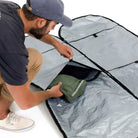 Man packing a surfboard bag